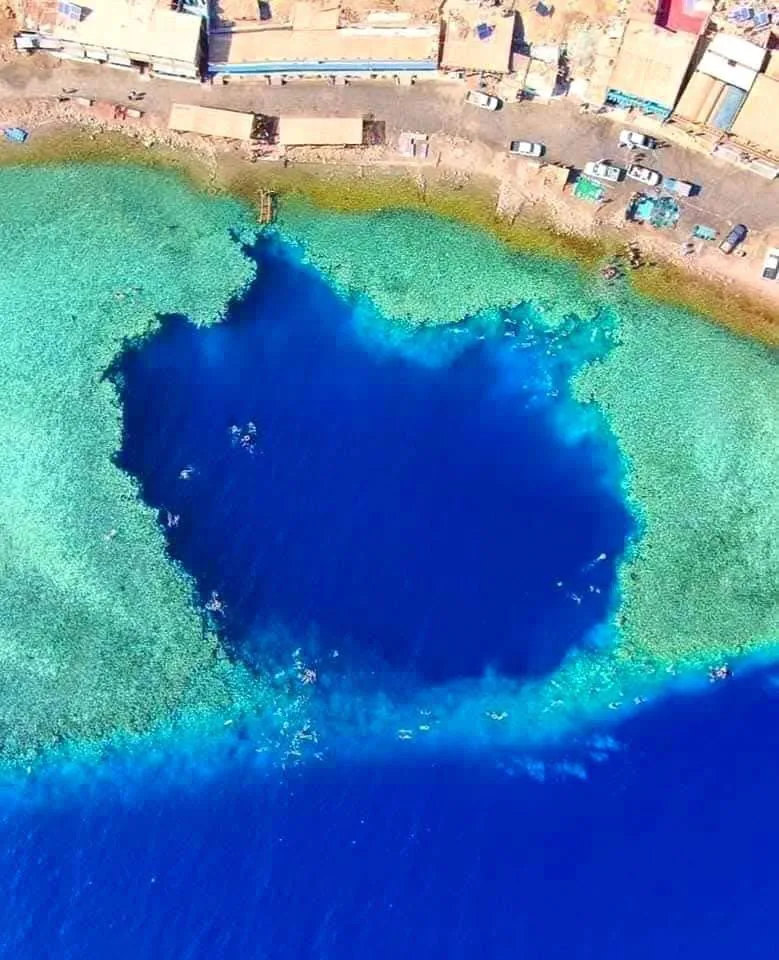 The Blue Hole of Dahab seen from above, a deep blue circle in the reef shelf