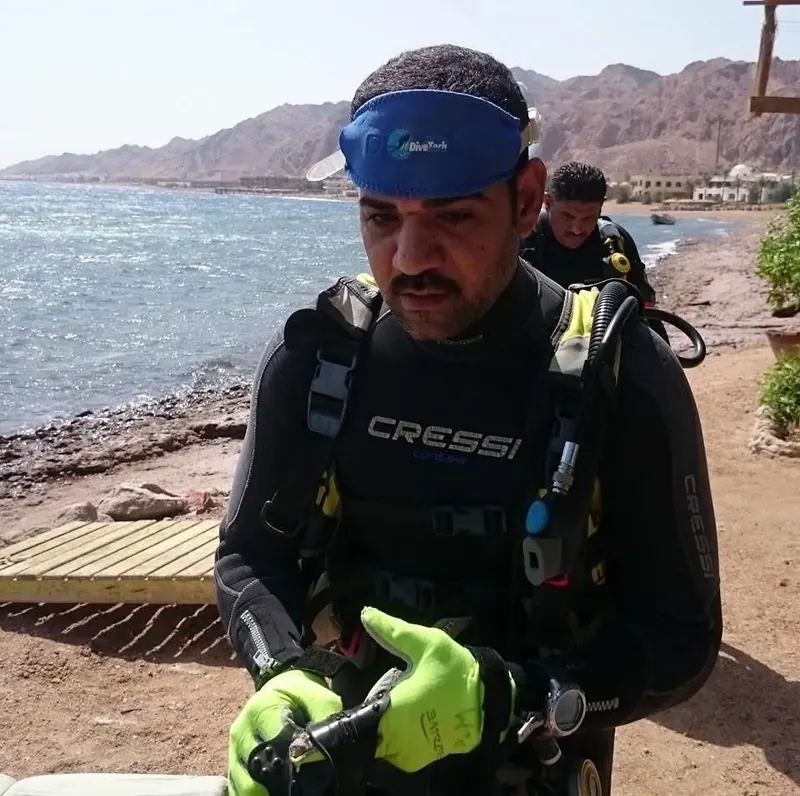 Osama getting ready on the shore, with the Sinai mountains behind him